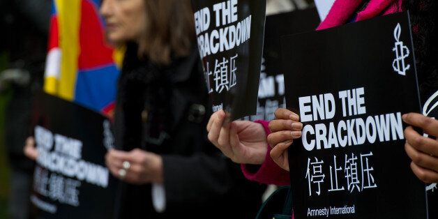 An Amnesty International supporter holds a sign with the slogan 'end the crackdown' in protest against claims of a deterioration in human rights and censorship of the internet and media during a state visit by Chinese President Xi Jinping