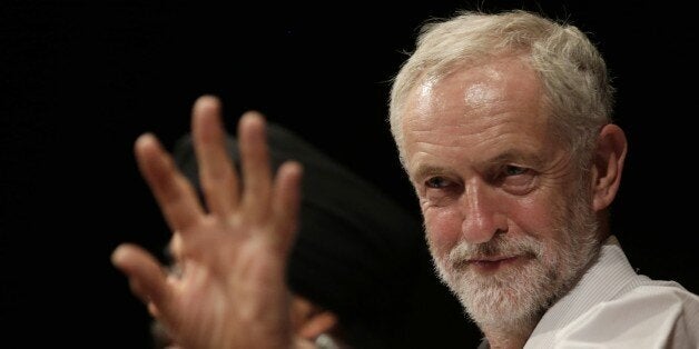 British lawmaker Jeremy Corbyn waves to a member of the audience prior to addressing a meeting during his election campaign for the leadership of the British Labour Party in Ealing, west London, Monday, Aug. 17, 2015. (AP Photo/Alastair Grant)