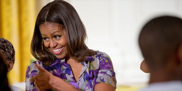 First lady Michelle Obama gives a thumbs up to children who participated in events with the