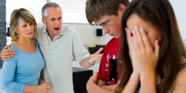 Parents scolding their teenage son and daughter