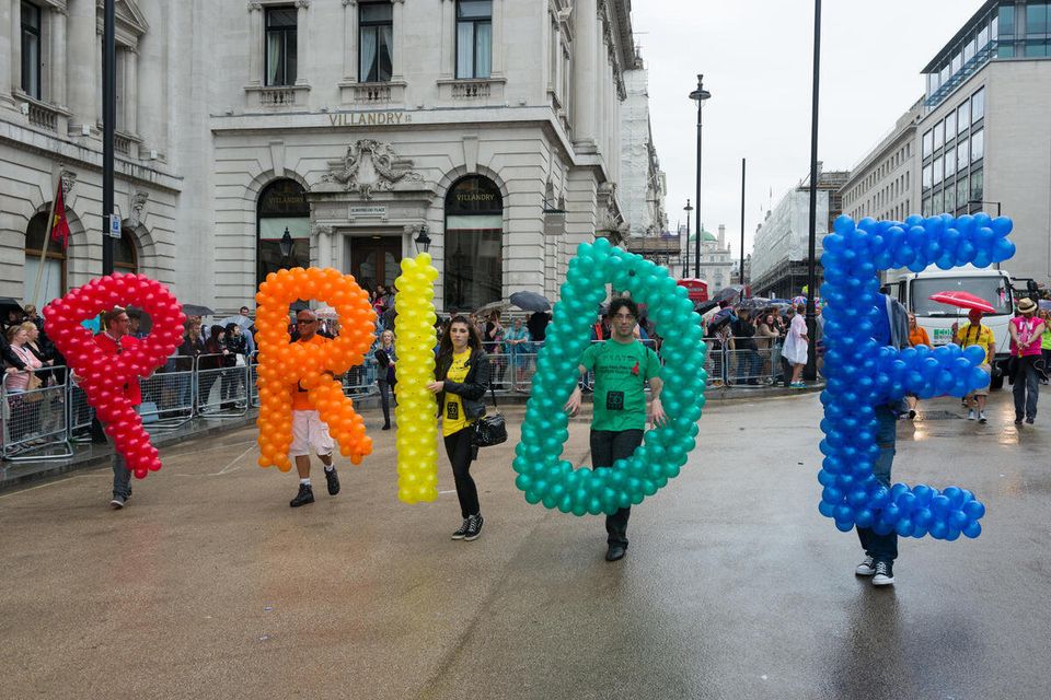 Revellers carrying coloured balloons that spell out the word Pride, during the Pride in London parade 2014, London, England