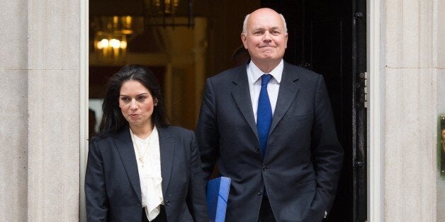 Employment Minister Priti Patel (L) and Work and Pensions Secretary Iain Duncan Smith leave the first weekly cabinet meeting in Downing Street following the May election