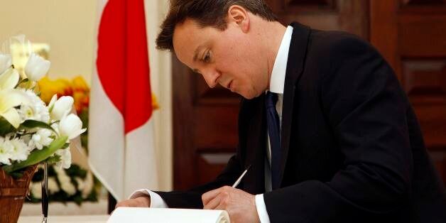 Britain's Prime Minister David Cameron signs a book of condolence for the victims of the recent earthquake and tsunami at the Japanese embassy in London Tuesday March 22, 2011. (AP Photo/Stefan Wermuth, Pool)