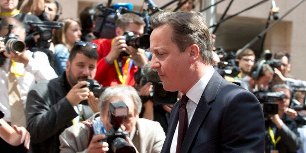 British Prime Minister David Cameron walks by the media as he arrives for an EU summit in Brussels on Thursday, June 25, 2015. Greece and its creditors launched a new round of talks in Brussels early Thursday in a fresh bid to unlock billions of euros in loans and save the country from bankruptcy. (AP Photo/Virginia Mayo)