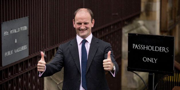 Newly elected U.K. Independence Party (UKIP) Member of Parliament Douglas Carswell gives a double thumbs-up as he poses for the media upon his arrival to take his seat at the Houses of Parliament in London, Monday, Oct. 13, 2014. The U.K. Independence Party won a seat in the British Parliament for the first time on Friday, a significant breakthrough for the anti-immigration force and a protest vote against the country's mainstream parties. UKIP candidate Douglas Carswell won the special election in the eastern England constituency of Clacton-on-Sea with 21,113 votes. (AP Photo/Matt Dunham)