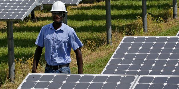 In this Wednesday, May 13, 2015 photo, Henry Plange, a power generation engineer, walks beside some of the more than 37,000 solar panels at the Space Coast Next Generation Solar Center, in Merritt Island, Fla. Industry experts rank Florida third in the nation in rooftop solar energy potential but 13th in the amount of solar energy generated. (AP Photo/John Raoux)