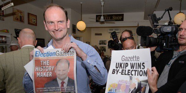Newly-elected UK Independence Party (UKIP) MP Douglas Carswell (L) poses for photographers with a copy of the local paper in Clacton-on-Sea, in eastern England, on October 10, 2014. Britain's anti-EU UK Independence Party won its first seat in the House of Commons Friday, sending jitters through Prime Minister David Cameron's Conservatives seven months before what is likely to be a tight general election. AFP PHOTO / LEON NEAL (Photo credit should read LEON NEAL/AFP/Getty Images)