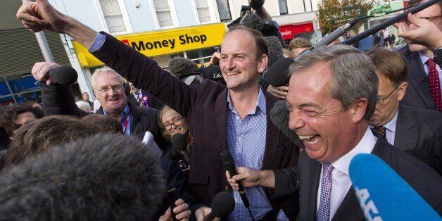 Newly elected UK Independence Party (UKIP) MP Douglas Carswell (C) and party leader Nigel Farage (R) are pictured as they celebrate in Clacton-on-Sea, in eastern England, on October 10, 2014. Britain's anti-EU UK Independence Party won its first seat in the House of Commons Friday, sending jitters through Prime Minister David Cameron's Conservatives seven months before what is likely to be a tight general election. AFP PHOTO / JUSTIN TALLIS (Photo credit should read JUSTIN TALLIS/AFP/Gett