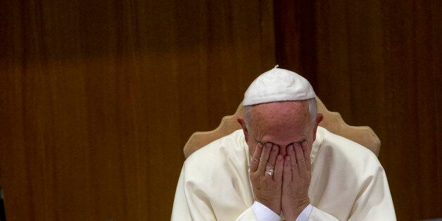 Pope Francis rubs his face during a morning session of a two-week synod on family issues, at the Vatican, Friday, Oct. 10, 2014. Gay rights groups are cautiously cheering a shift in tone from the Catholic Church toward homosexuals, encouraged that Pope Francis' famous