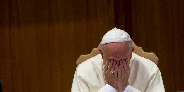 Pope Francis rubs his face during a morning session of a two-week synod on family issues, at the Vatican, Friday, Oct. 10, 2014. Gay rights groups are cautiously cheering a shift in tone from the Catholic Church toward homosexuals, encouraged that Pope Francis' famous