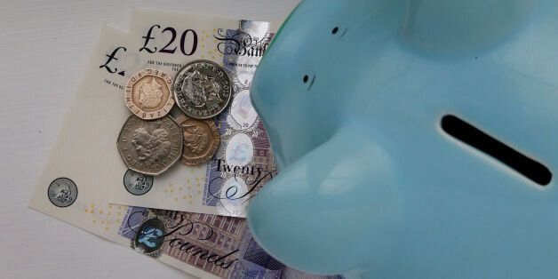 File photo dated 06/01/15 of money in a piggy bank, as the UK population is spending more and has a greater amount of money available to save each month after paying direct taxes, a quarterly health check of the country's economic well-being has shown.