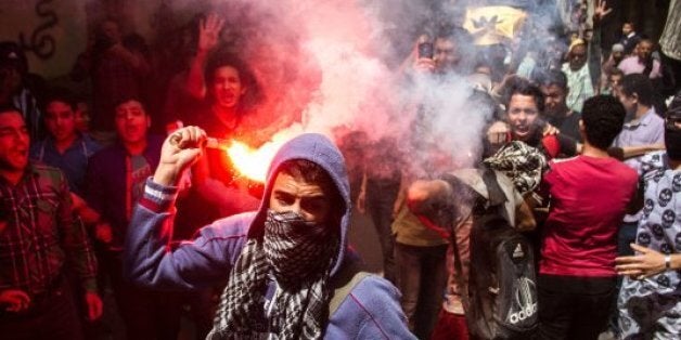 FILE - In this April 24, 2015 file photo, an Egyptian youth carries a lit flare as supporters of the Muslim Brotherhood gather in the El-Mataria neighborhood of Cairo, Egypt, to protest the 20-year sentence for ousted president Mohammed Morsi and verdicts against other prominent figures of the Brotherhood. Egyptian police are increasingly detaining activists and students in secret, snatching them from homes or the street and holding them for weeks as their families scramble to find them. Activis