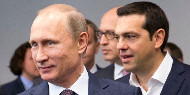 Russian President Vladimir Putin, foreground, and Greek Prime Minister, behind him, Alexis Tsipras arrive for their talks at the St. Petersburg International Investment Forum in St.Petersburg, Russia, Friday, June 19, 2015.Russia is willing to consider giving financial aid to Greece, President Vladimir Putin's spokesman said Friday ahead of talks between the leaders of the two countries. (AP Photo/Alexander Zemlianichenko)