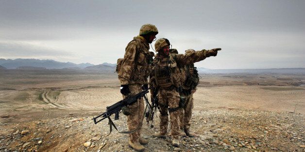 A soldier of 42 Commandos of British Royal Marines points at a location of Taliban militants during an operation near Kajaki, southern Afghanistan, Saturday, Jan. 13, 2007.