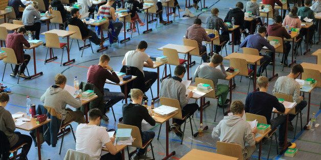 High school students sit at their tables during the final school leaving exams (Abitur) at the ecumenical Domgymnasium (high school) in Magdeburg, Germany, 29 April 2015. Around 5,600 high school students are taking their School leaving exams in Saxony-Anhalt until 11 May 2015. Photo: Jens Wolf/dpa
