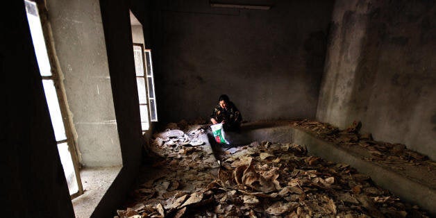 DAHUK, IRAQ: A Yazidi woman sits inside a room covered with bread at the Lalesh temple situated in a valley near Dahuk, 430 Kilometers (260 miles) northwest of Baghdad, during the community's congregation ritual, 10 October 2006. On the fourth day of ceremonies of the Eid al-Jamaa, Yazidis continued to visit the temple of Lalesh, the holiest site for Yazidis and one of the oldest continuously visited religious sites in Iraq. Yazidis, who are believed to number about 1.2 million in the world th