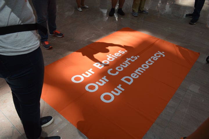 Activists spread out a banner about reproductive rights on the floor of the Hart Senate Office Building.