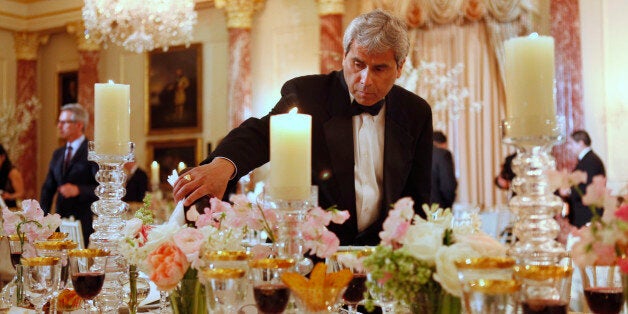 A waiter fills wine glasses before the arrival of U.S. Secretary of State Hillary Rodham Clinton, British Prime Minister David Cameron, and U.S. Vice President Joe Biden to a luncheon at the State Department in Washington, on Wednesday, March 14, 2012. (AP Photo/Jacquelyn Martin)