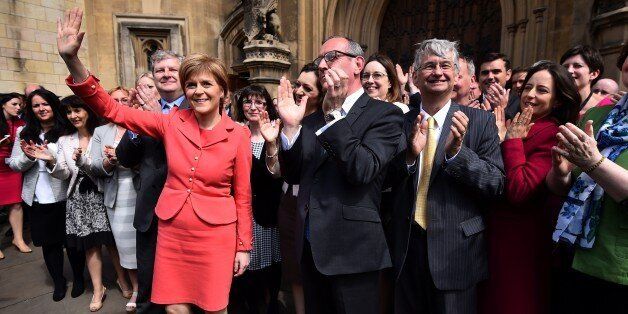 Scotland's First Minister and leader of the Scottish National Party (SNP), Nicola Sturgeon (L), poses during a photocall with newly-elected SNP members of parliament (MPs) outside the Houses of Parliament in London on May 11, 2015. The SNP won a landslide in Scotland in the May 7 general election, destroying the Labour party north of the border in a historic leap forward which could increase pressure for a fresh referendum on independence. The nationalists won 56 of 59 parliamentary seats in Sco