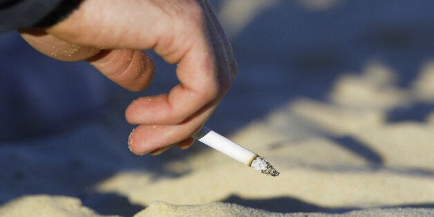 SYDNEY - MAY 19: A smoker enjoys a cigarette on Bondi Beach May 19, 2004 in Sydney, Australia. Waverley Council has passed a motion to investigate the legalities and enforcement of a smoking ban on the Council's beaches, including Bondi, after Manly Council recently outlawed smoking on beaches, making it the first place in the world outside Los Angeles to do so. Data from Clean Up Australia showed 32 billion cigarette butts were dropped in Australia each year, and that at any given time there w