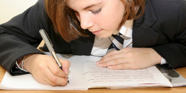 Education, School, Girl in uniform writing in exercise book.