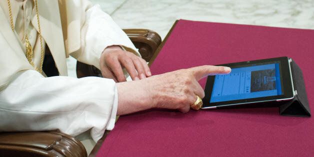In this photo provided by the Vatican newspaper L'Osservatore Romano, Pope Benedict XVI pushes a button on a tablet at the Vatican, Wednesday, Dec. 12, 2012. In perhaps the most drawn out Twitter launch ever, Pope Benedict XVI pushed the button on a tablet brought to him at the end of his general audience Wednesday. It read: