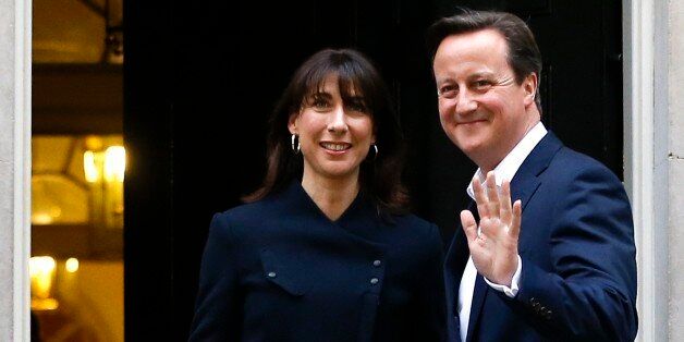 Britain's Prime Minister David Cameron and his wife Samantha return to 10 Downing Street in London, Friday, May 8, 2015. The Conservative Party surged to a surprisingly commanding lead in Britain's parliamentary election, with returns Friday backing an exit poll's prediction that Prime Minister David Cameron would remain in 10 Downing Street. (AP Photo/Kirsty Wigglesworth)