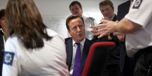 Britain's Prime Minister David Cameron talks with United Kingdom Border Agency officials in their control room, during a visit to Terminal 5 at London's Heathrow airport, Monday Oct. 10, 2011. Cameron met border staff and viewed the latest facial recognition technology used at passport control, ahead of a major speech on immigration. Around 150 people are refused entry to the United Kingdom each week, and about 350 are stopped for questioning.(AP Photo/Richard Pohle, pool)
