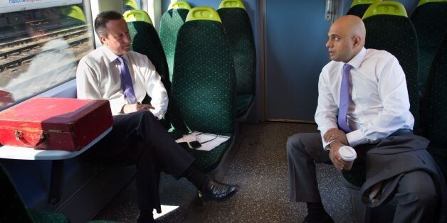 Prime Minister David Cameron and Sajid Javid, secretary of state for culture media and sport as they travel by train to Purfleet in Essex where they met apprentices at the Royal Opera House Production Workshop who make scenery for the famous theatre in London.