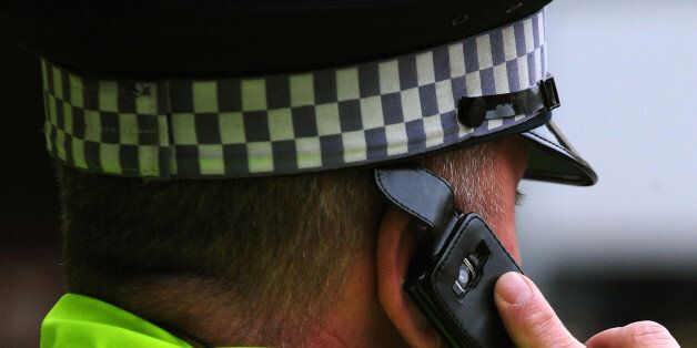 Nottingham Police Officer using a mobile phone, in Nottingham.