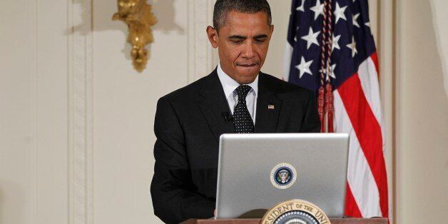 President Barack Obama uses a laptop computer to send a tweet during a