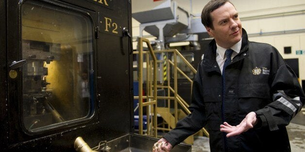 Britain's Chancellor of the Exchequer George Osborne holds freshly minted coins during a visit to the Royal Mint in Llantrisant, Wales on March 25, 2014. In events surrounding the Chancellor's recent budget, a new design was revealed for a 12-sided one pound coin, designed to be much harder to fake and based on the pre-decimal 'threepenny bit' three pence piece. AFP PHOTO/POOL/Matthew Horwood (Photo credit should read MATTHEW HORWOOD/AFP/Getty Images)