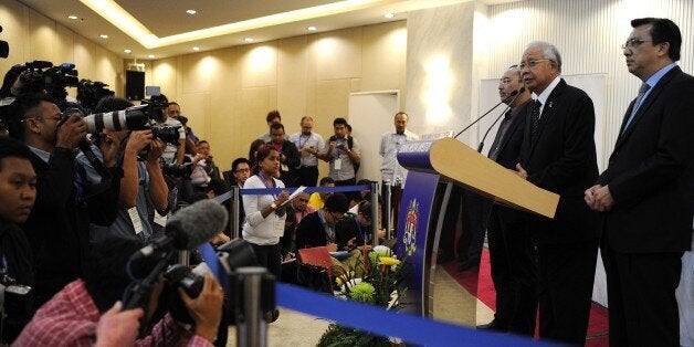 Malaysia's Prime Minister Najib Razak (2nd-R) delivers a statement on the missing Malaysia Airlines flight MH370 days after the discovery of a washed-up plane part on the French Indian Ocean island of La Reunion during a press conference in Kuala Lumpur early on August 6, 2015. Debris found on the islan a week ago is from MH370, Razak announced on, confirming for the first time that the plane which mysteriously disappeared 17 months ago had crashed. AFP PHOTO / MOHD RASFAN (Photo credit s