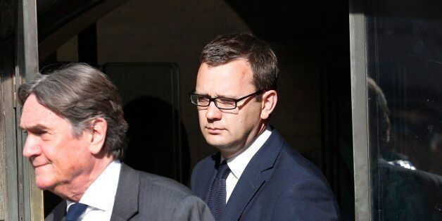 Andy Coulson, background, former News of the World editor leaves the Central Criminal Court in London, Tuesday, June 24, 2014. Coulson was convicted of phone hacking Tuesday, but fellow editor Rebekah Brooks was acquitted after a trial centering on illegal activity at the heart of Rupert Murdoch's newspaper empire. A jury at London's Old Bailey unanimously found Coulson, the former spin doctor of British Prime Minister David Cameron, guilty of conspiring to intercept communications. Brooks was acquitted of that charge and of counts of bribing officials and obstructing police. The nearly eight-month trial was triggered by revelations that for years the News of the World used illegal eavesdropping to get stories, listening in on the voicemails of celebrities, politicians and even crime victims. (AP Photo/Lefteris Pitarakis)