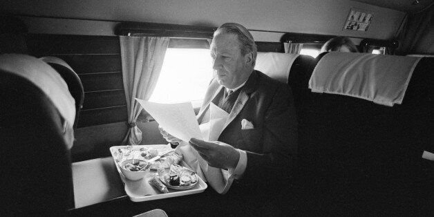 15th March 1966: British Conservative party leader Edward Heath reading papers and eating on board a plane during the general election campaign. (Photo by Terry Fincher/Express/Getty Images)