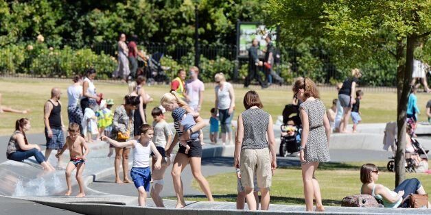 People cool off in part of the Princess Diana Memorial Fountain in Hyde Park, London, as temperatures are set to soar to as high as 35C in Britain - amid fears that the heat could disrupt rail services.
