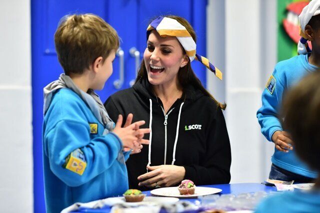 The Duchess of Cambridge, lifts her blindfold, after being helped to ice a cake by Fynley Gooch, aged seven, as she promotes disability awareness when she met with children at the newly established 23rd Poplar Beaver Scout Colony in east London. PRESS ASSOCIATION Photo. Picture date: Tuesday December 16, 2014. Kateâs visit supports the Scout Association's 'Better Prepared' campaign, which aims to help communities to deliver Scouting to two hundred locations across the UK where Scouting can have the biggest impact. Photo credit should read: Ben Stansall/PA Wire