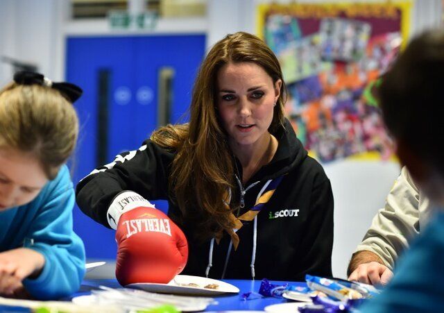 The Duchess of Cambridge learns about disability by wearing a boxing glove to undertake simple tasks as she meets with children at the newly established 23rd Poplar Beaver Scout Colony in east London. PRESS ASSOCIATION Photo. Picture date: Tuesday December 16, 2014. Kateâs visit supports the Scout Association's 'Better Prepared' campaign, which aims to help communities to deliver Scouting to two hundred locations across the UK where Scouting can have the biggest impact. Photo credit should read: Ben Stansall/PA Wire