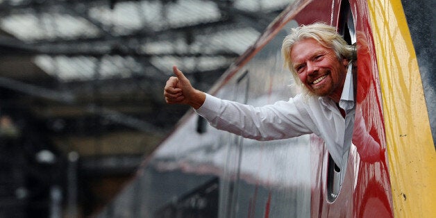 British entrepreneur Sir Richard Branson leans out of the window of the driver's cab on board a Virgin Pendolino train at Lime Street Station in Liverpool, north-west England, on March 13, 2012, as he prepares to launch a Global Entrepreneurship Congress. The event aims to be the largest gathering of start-up champions from around the world. AFP PHOTO/PAUL ELLIS (Photo credit should read PAUL ELLIS/AFP/Getty Images)