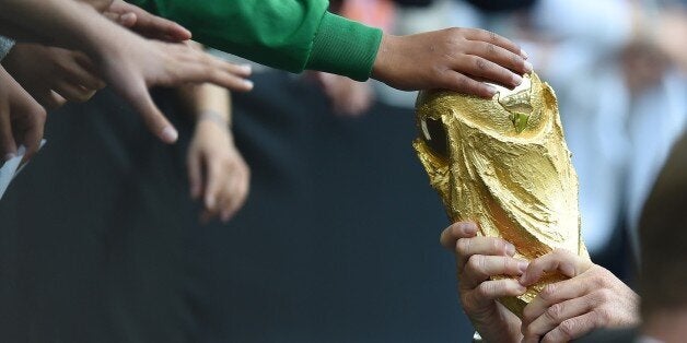 Germany's head coach Joachim Loew shows the world cup trophy to fans during a public training session of the German national football team in Duesseldorf, Germany on September 1, 2014. Germany's squad prepares for the upcoming friendly game against Argentina on September 3, 2014 in Duesseldorf. AFP PHOTO / PATRIK STOLLARZ (Photo credit should read PATRIK STOLLARZ/AFP/Getty Images)