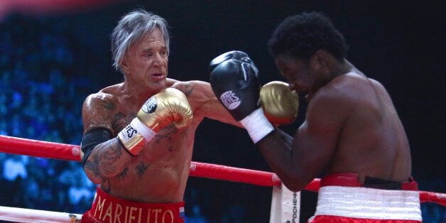 US actor Mickey Rourke, left, punches his opponent Elliot Seymour of the United States, during their professional boxing match at the Luzhniki Stadium, in Moscow, Russia, on Friday, Nov. 28, 2014. Hollywood actor Mickey Rourke returned to the boxing ring Friday at the age of 62, defeating a fighter less than half his age in an exhibition bout. (AP Photo/Denis Tyrin)