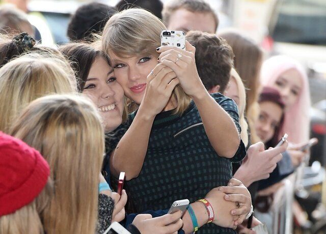 Picture Shows: Taylor Swift October 09, 2014 Pop sensation Taylor Swift seen arriving at the BBC Radio One studios in London, England. The 'Shake It Off' singer was wearing a checked top with a matching mini skirt over black tights and high-heeled ankle boots as she happily stopped to pose for photos with several eager fans. Non Exclusive WORLDWIDE RIGHTS Pictures by : FameFlynet UK Â© 2014 Tel : +44 (0)20 3551 5049 Email : info@fameflynet.uk.com