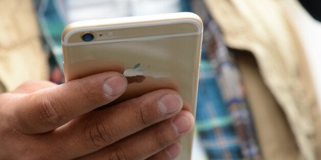 Tony Zhan checks out his new iPhone 6 Plus outside the Apple store in Pasadena, California on the first day of sale, September 19, 2014. The California tech giant has said more than four million pre-orders were received in the 24 hours after the sale of the new devices was announced. AFP PHOTO / ROBYN BECK (Photo credit should read ROBYN BECK/AFP/Getty Images)