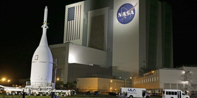 The Orion Spacecraft moves by the Vehicle Assembly Building on its approximately 22 mile journey from the Launch Abort System Facility at the Kennedy Space Center to Space Launch Complex 37B at the Cape Canaveral Air Force Station, Tuesday, Nov. 11, 2014, in Cape Canaveral, Fla. The test flight for Orion is scheduled to launch on Dec. 4.(AP Photo/John Raoux)