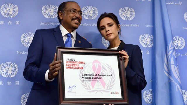 Executive Director of Joint UN Programme on HIV/AIDS Michel Sidibe (L) presents British fashion designer Victoria Beckham with a UNAIDS international goodwill ambassador certificate during a press conference on the sideline of the 69th Session of the UN General Assembly at the United Nations in New York on September 25, 2014. AFP PHOTO/Jewel Samad (Photo credit should read JEWEL SAMAD/AFP/Getty Images)