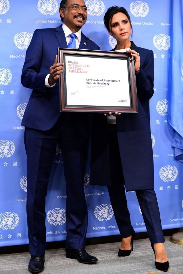 Executive Director of Joint UN Programme on HIV/AIDS Michel Sidibe (L) presents British fashion designer Victoria Beckham with a UNAIDS international goodwill ambassador certificate during a press conference on the sideline of the 69th Session of the UN General Assembly at the United Nations in New York on September 25, 2014. AFP PHOTO/Jewel Samad (Photo credit should read JEWEL SAMAD/AFP/Getty Images)