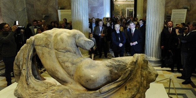 Neil MacGregor (C-R), director of the British Museum, Mikhail Piotrovsky (C-L), director of Hermitage Museum, stand near the sculpture of the Greek river god Ilissos at the State Hermitage Museum on December 5, 2014 in St. Petersburg. Part of the 'Elgin Marbles', named after British diplomat Lord Elgin who took them from Greece's in 1803, has left Britain for the first time since they were taken from the Parthenon, on loan to a Russian museum. The statue will be displayed from this Saturday unti