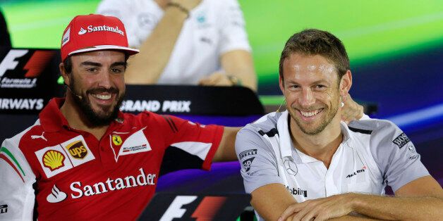 Ferrari driver Fernando Alonso of Spain, left, and McLaren Mercedes driver Jenson Button of Britain share a lighter moment during a news conference at the Yas Marina racetrack in Abu Dhabi, United Arab Emirates, Thursday, Nov. 20, 2014. With double points on offer in the Formula One finale, there could yet be a bitter twist to the fascinating title duel between Mercedes teammates Lewis Hamilton and Nico Rosberg at the Abu Dhabi Grand Prix. The Emirates Formula One Grand Prix will take place on Sunday. (AP Photo/Hassan Ammar)