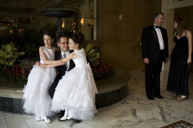 COLORADO SPRINGS, CO - MAY 16: Robert Moore poses for a photograph with his 9-year-old twin daughters Lauren and Elizabeth on May 16, 2008 in Colorado Springs, Colorado. The annual Father-Daughter Purity Ball, founded in 1998 by Randy and Lisa Wilson, focuses on the idea that a trustworthy and nurturing father will influence his daughter to lead a lifestyle of 'integrity and purity.' (Photo by Marvi Lacar/Getty Images)