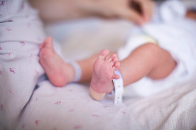 Newborn baby girl with identity tag on feet, close up